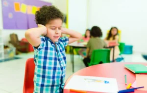 Child stretching arms in preschool classroom