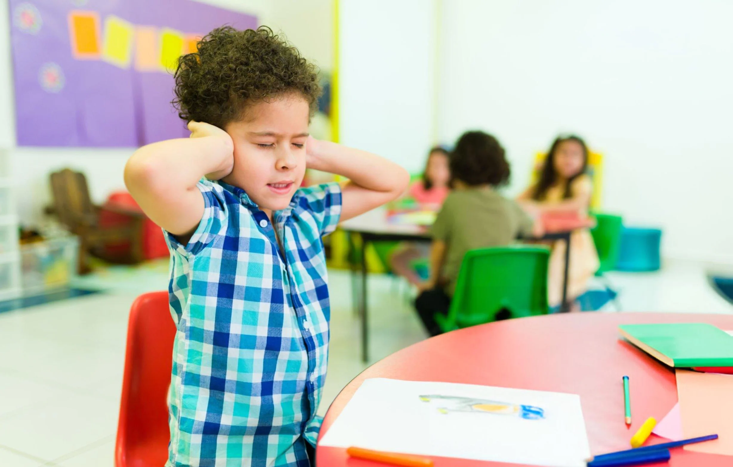 Child stretching arms in preschool classroom
