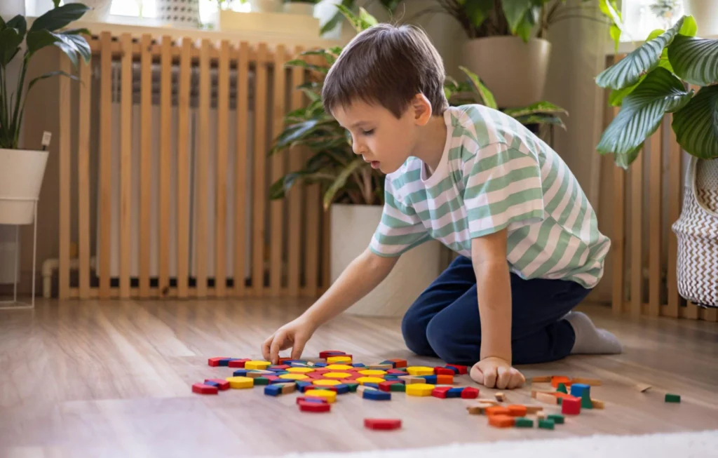 Boy arranging learning blocks on floor